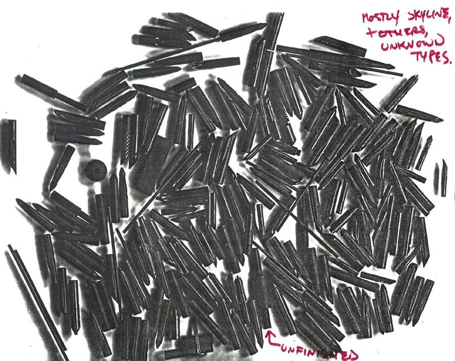 A heap of nibs and feeds, mostly Skyline, with unfinished ones, annotated by hand.